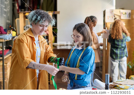 Waist up portrait of two teenage girls decorating prosthetics in inclusive crafting class Waist up portrait of two teenage girls decorating prosthetics in inclusive crafting class 112293031