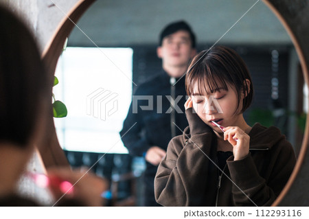 A woman brushing her teeth in front of the bathroom mirror in the morning A woman brushing her teeth in front of the bathroom mirror in the morning 112293116