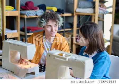 Portrait of two teenage girls with disability chatting while working in inclusive atelier studio 112293531