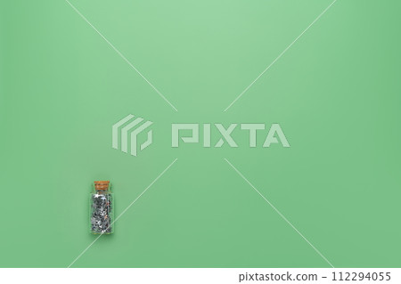 Glass phial with cork stopper and full of magic lucky silver stars. St Patrick's holiday background for greeting cards or party banner templates 112294055