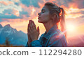 Woman Praying in the Mountains at Sunset in Y2K Aesthetic 112294280