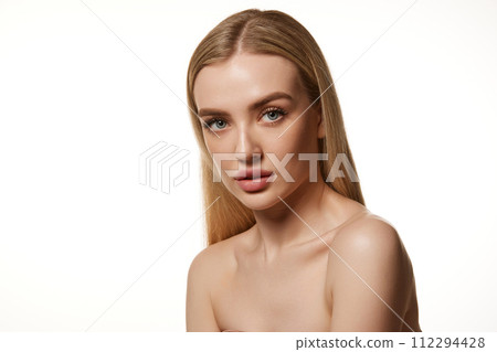 Portrait of beautiful young woman with straight blonde air, smooth, clean skin, plump lips and bare shoulders isolated against white studio background Portrait of beautiful young woman with straight blonde air, smooth, clean skin, plump lips and bare shoulders isolated against white studio background 112294428