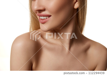 Close-up cropped image of blonde young woman with bare shoulders and neck visible isolated against white studio background 112294439