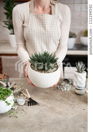 Woman holding Aloe Aristata house plant with roots for replanting 112294592