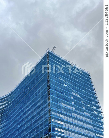 Buildings under construction with construction crane under a blue sky 112294661