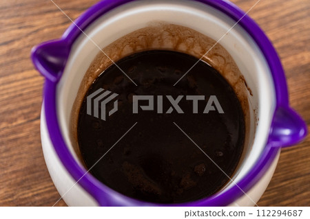 Carefully greasing a bundt cake pan in preparation for baking a delicious gingerbread bundt cake with caramel frosting. Carefully greasing a bundt cake pan in preparation for baking a delicious gingerbread bundt cake with caramel frosting. 112294687