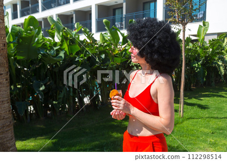 Brunette woman in short clothes drinks a drink on a sunny day, copy space Brunette woman in short clothes drinks a drink on a sunny day, copy space 112298514