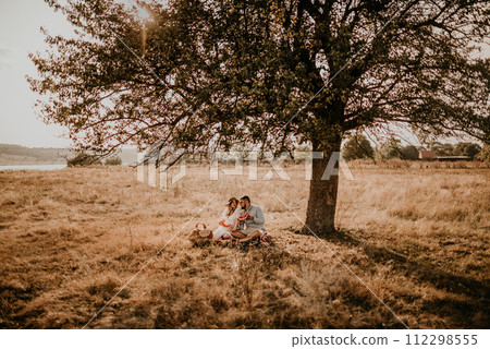 happy European caucasian family with pregnant woman relaxing in nature picnic eating 112298555