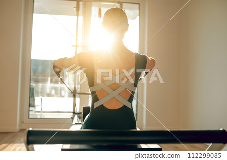 Athletic female engage in Pilates exercises training flexibility and muscle strength Athletic female engage in Pilates exercises training flexibility and muscle strength 112299085