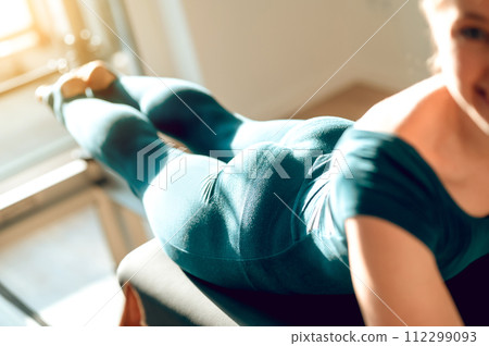 Athletic female engage in Pilates exercises training flexibility and muscle strength Athletic female engage in Pilates exercises training flexibility and muscle strength 112299093