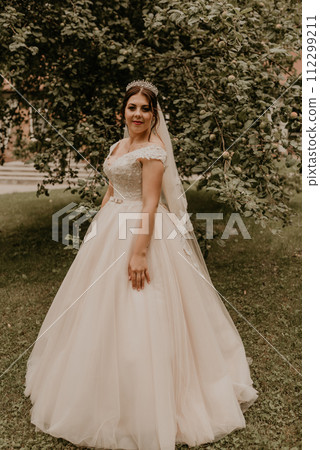 Caucasian young woman bride spinning whirls dancing posing moving at nature 112299211