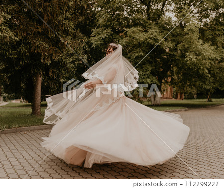 Caucasian young woman bride spinning whirls dancing posing moving at nature 112299222