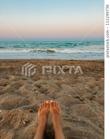 Woman legs barefoot. Sea blue aquamarine waves sand beach. ocean foam. Woman legs barefoot. Sea blue aquamarine waves sand beach. ocean foam. 112299736