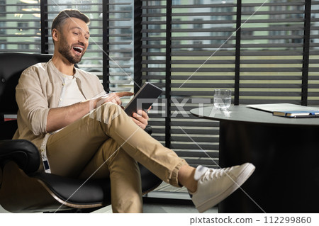 Young bearded man in beige clothes working in the office 112299860