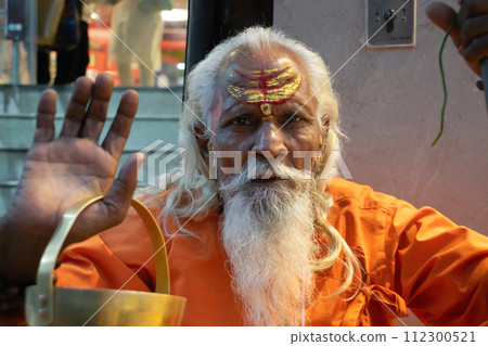 Ascetic monk Sadhu in India with beard, white hair and painted face preaching Ascetic monk Sadhu in India with beard, white hair and painted face preaching 112300521