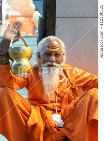 Ascetic monk Sadhu in India with beard, white hair and painted face preaching Ascetic monk Sadhu in India with beard, white hair and painted face preaching 112300525