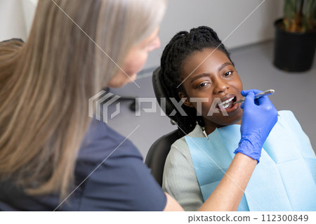 Multicultural lady in dental clinic doing teeth checkup Multicultural lady in dental clinic doing teeth checkup 112300849