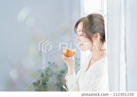 A woman who drinks tea at the window side 112301150