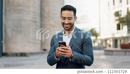 Asian businessman, mobile message and walking in city, view and confident professional in career by office buildings. Young lawyer, chat and smartphone for connection and technology in cbd in town 112301729