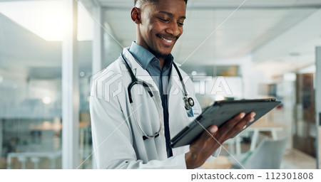 Tablet, research and happy black man doctor on internet for medical or healthcare information online in a hospital. Smile, medicine and professional typing on health website or app in a modern clinic 112301808