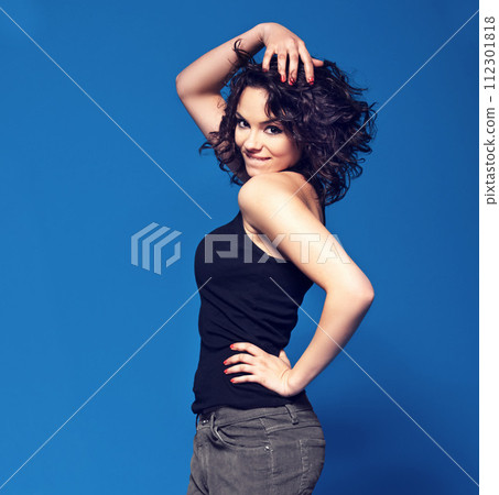 Fashion, fun and portrait of woman with smile, confidence and energy on blue background. Pride, flirt and happy gen z girl with casual style, relax and excited model with positive attitude in studio 112301818