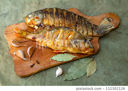 Fried appetizing fish on barbecue, picnic food close-up 112302126