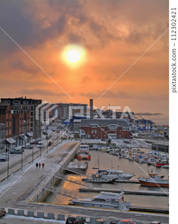 Sun, city and harbor with top view of street, buildings and boat in ocean for travel with people walking on path. Adventure, tourism and destination with transport, urban road and outdoor in Norway Sun, city and harbor with top view of street, buildings and boat in ocean for travel with people walking on path. Adventure, tourism and destination with transport, urban road and outdoor in Norway 112302421