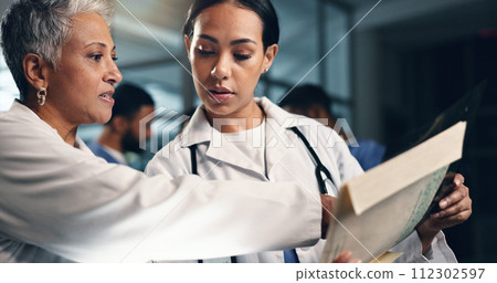 Doctor, women together and tablet in night, documents or analysis for results, decision or info in hospital. Mature medic, partnership and paperwork for healthcare, wellness and planning with choice 112302597