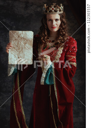 happy medieval queen in red dress with parchment and crown happy medieval queen in red dress with parchment and crown 112303557