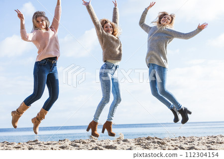 Three women jumping 112304154