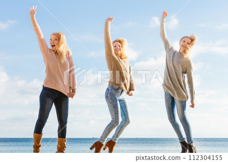 Three women jumping 112304155