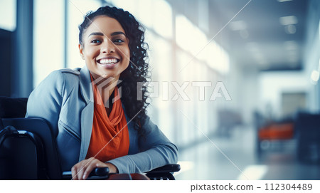 Happy, smiling young dark-skinned, black, African American girl student in a wheelchair in the foyer of an educational institution. Happy, smiling young dark-skinned, black, African American girl student in a wheelchair in the foyer of an educational institution. 112304489
