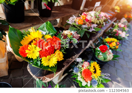 Many colorful array of fresh flower bouquets on display at an outdoor street city market on warm spring sunny day. Bright blossoming plants retail store at Bremen Germany Many colorful array of fresh flower bouquets on display at an outdoor street city market on warm spring sunny day. Bright blossoming plants retail store at Bremen Germany 112304563