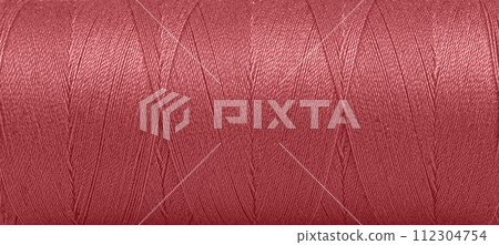 Texture of threads in a spool of red color on a white background 112304754