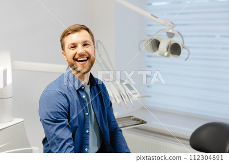 Man's smile is perfect. Portrait of happy patient in dental chair after appointment 112304891