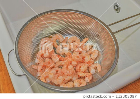 Cooked and peeled prawns in strainer. Food photography. Healthy food 112305087