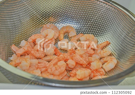Cooked and peeled prawns in strainer. Food photography. Healthy food Cooked and peeled prawns in strainer. Food photography. Healthy food 112305092