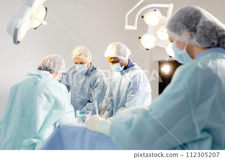 Group of doctors performing surgery in operating room 112305207