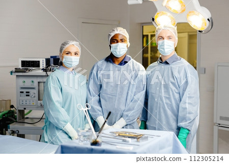 Group of doctors discussing patient cases around table 112305214