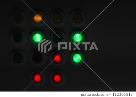 Dark industrial control panel with colorful illuminated buttons 112305512