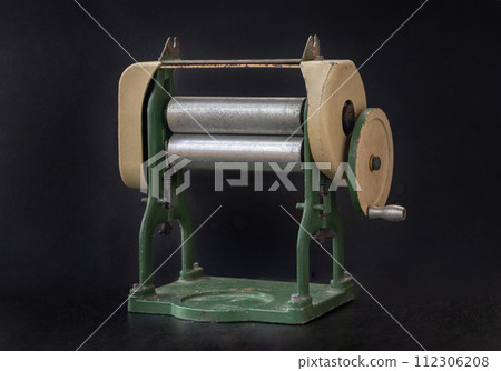 Antique pasta maker with hand crank on dark background. Antique pasta maker with hand crank on dark background. 112306208