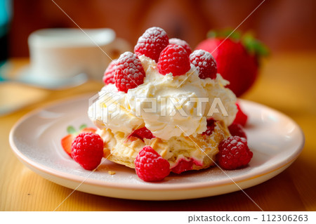 Dessert topped with fluffy vanilla-flavored whipped cream and fresh raspberries. Chantilly or Clotted Cream 112306263