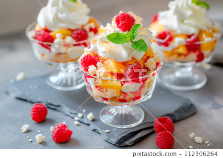 Vanilla peach dessert or melba ice cream with peach fruits. Colorful assortment of fruit salad topped with whipped cream 112306264