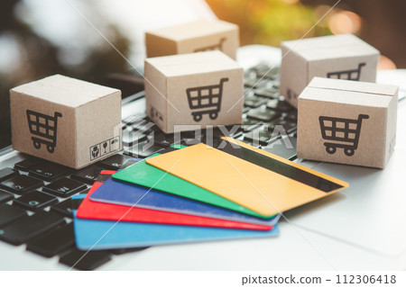 Shopping online. Credit card and cardboard box with a shopping cart logo on laptop keyboard. Shopping service on The online web. offers home delivery 112306418
