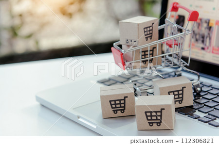 Shopping online. cardboard box with a shopping cart logo in a trolley on laptop keyboard. Shopping service on The online web. offers home delivery Shopping online. cardboard box with a shopping cart logo in a trolley on laptop keyboard. Shopping service on The online web. offers home delivery 112306821