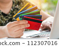 Credit card payment. Woman hands holding credit card and using laptop. Online shopping 112307016