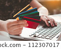 Credit card payment. Woman hands holding credit card and using laptop. Online shopping 112307017