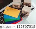 Shopping online. Credit card and cardboard box with a shopping cart logo on laptop keyboard. Shopping service on The online web. offers home delivery 112307018