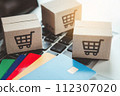 Shopping online. Credit card and cardboard box with a shopping cart logo on laptop keyboard. Shopping service on The online web. offers home delivery 112307020