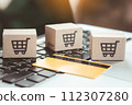 Shopping online. Credit card and cardboard box with a shopping cart logo on laptop keyboard. Shopping service on The online web. offers home delivery 112307280